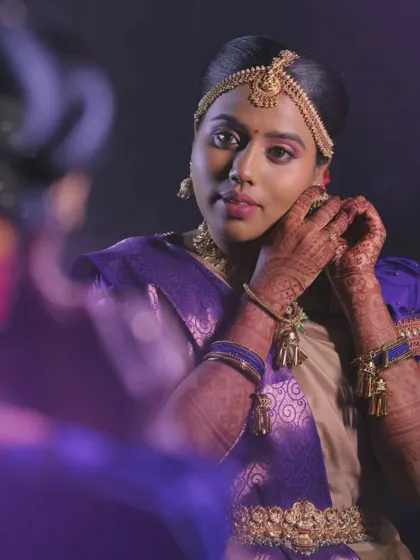 A minimalistic yet elegant muhurtham look for Priya. The focus is on clean lines and letting her natural beauty shine through her purple and gold saree.