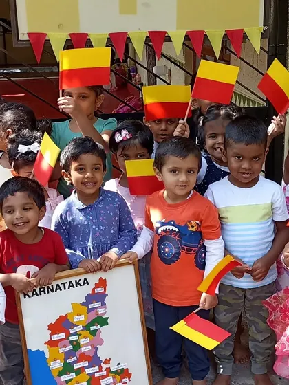 Children celebrating Kannada Rajyotsava, proudly holding the Karnataka flag.