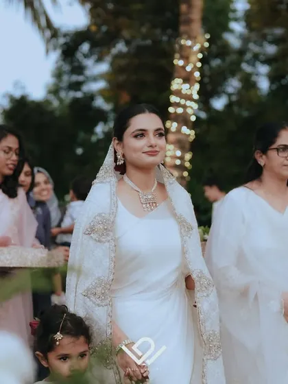 A bride makes her entrance at her wedding, surrounded by family and friends.