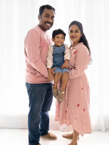 A standing portrait of the family, showcasing their coordinated outfits and happy expressions.