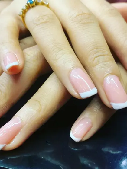 The epitome of timeless elegance. This is a close-up of our classic French manicure, featuring a flawless sheer pink base and crisp white tips on beautifully shaped squoval nails for a clean, polished finish.