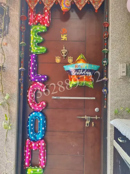A colorful and festive 'WELCOME' balloon arrangement for a birthday party door.