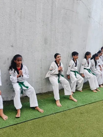 A long line of students holding the wall sit position. This drill also builds a sense of shared struggle and teamwork.