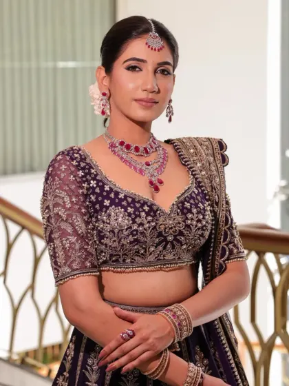A close-up of the bride Namrata's reception look. The deep purple velvet blouse with intricate embroidery pairs beautifully with the ruby and diamond necklace, creating a look of pure bahurani elegance.