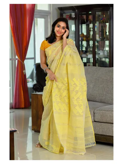 A light and airy portrait featuring a handwoven Dhakai Jamdani saree. The natural pose and home environment make this a perfect shot for a brand that emphasizes comfort and elegance.