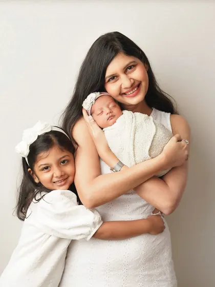 A mother and her two daughters share a hug. This photo is filled with warmth and the special bond between a mom and her children.