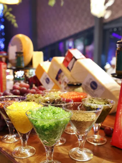 A close-up of our cheese and condiment station, featuring a variety of colourful toppings and spreads in martini glasses. This creative presentation elevates a simple cheese board into a visual spectacle.