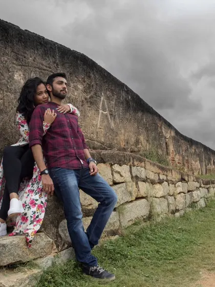 A quiet, intimate moment shared between a couple against the backdrop of Nandi Hills. The stormy sky adds a layer of cinematic drama to this pre-wedding portrait.