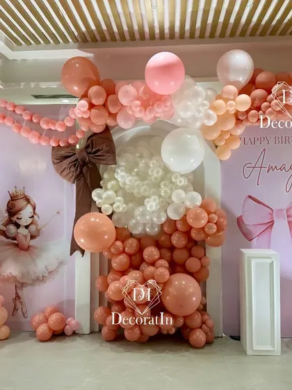 A "bow-tiful" fairytale setup for a 9th birthday. This elaborate backdrop is filled with pink and peach balloons, large bow details, and a ballerina illustration, creating a dreamy and delicate atmosphere for the birthday girl.
