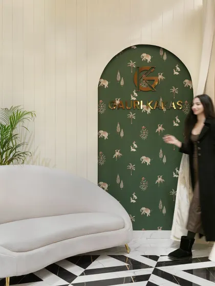 The waiting area of the makeup studio, featuring a custom-designed arched niche with branded wallpaper, a curved sofa, and our signature "brush stroke" flooring.