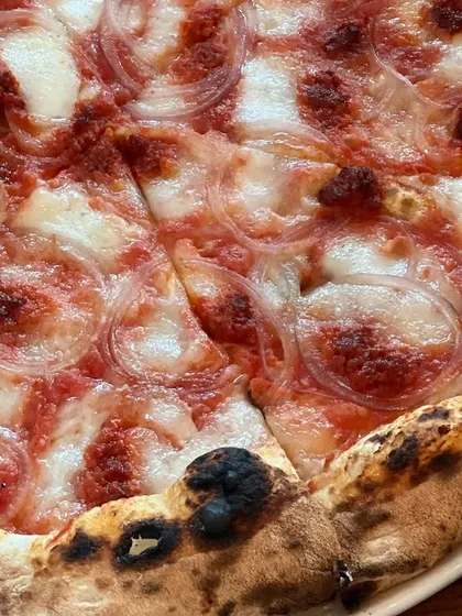 A detailed close-up of the Goan Sausage pizza, highlighting the texture of the crust and toppings.