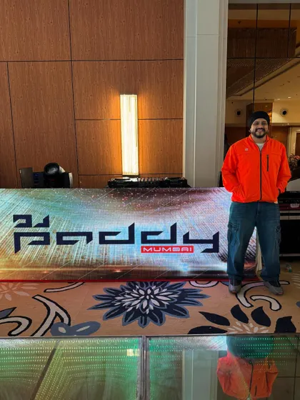 Arriving at the venue and getting ready behind my custom LED DJ booth. The booth features my logo and can be programmed with various lighting effects to match the event's theme.