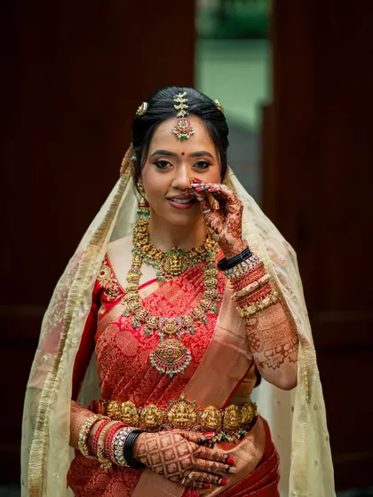 A playful, candid moment, showing the intricate details of her jewellery and the flawless makeup.
