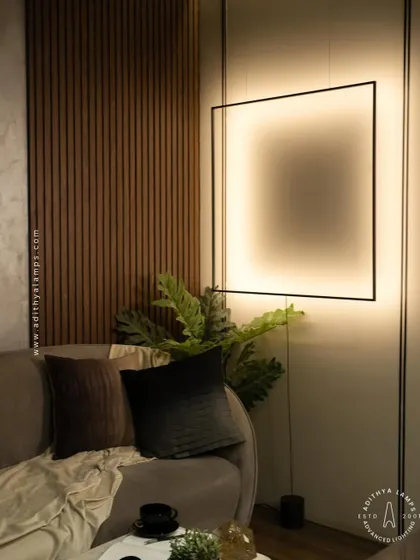 This unique floor-to-ceiling fixture features a large, suspended square frame that washes the wall with a soft, ambient light. It acts as both a light source and a bold, graphic art piece for a contemporary living room.