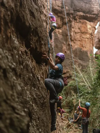 A climber looks back with a smile while on the wall. Our events are filled with these moments of connection and shared encouragement.