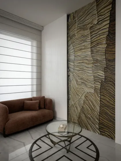 A cozy seating area within the master bedroom of The House of Dancing Screens is perfect for unwinding. A custom wall mural made of natural stone adds a unique, artistic texture to the space.