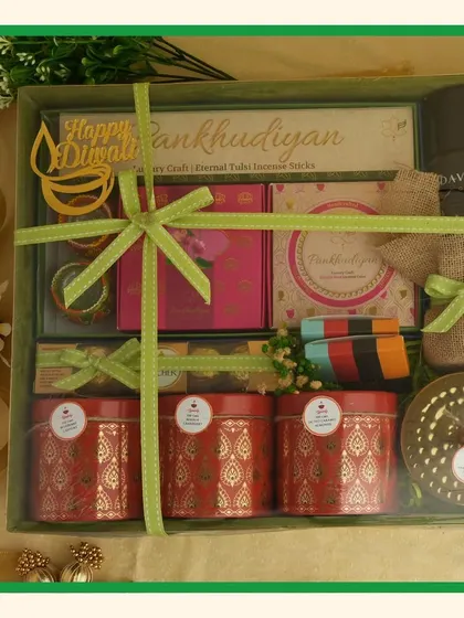 A full view of a large green-themed Diwali hamper, packed with items like Davidoff perfume, snacks, and decorative tins.