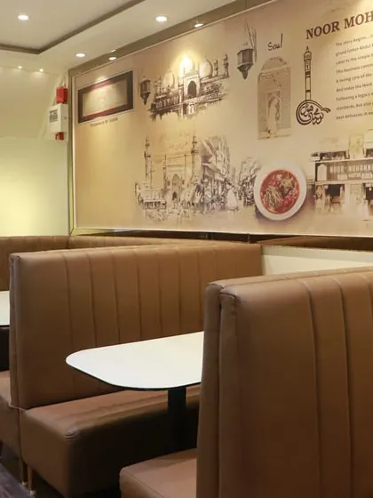 The comfortable booth seating at our Kurla restaurant, with a wall mural depicting our 100-year journey from Bhendi Bazaar.