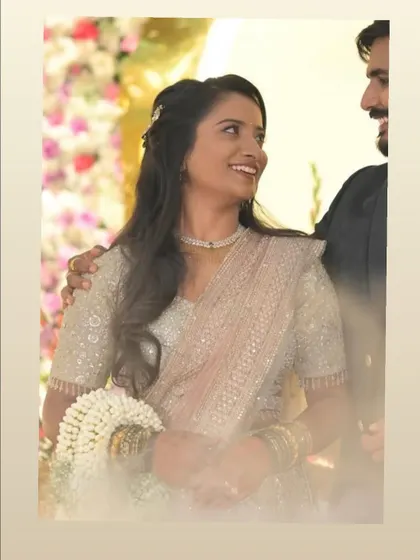A candid moment of happiness. Her makeup is soft and glowing, paired with a half-up hairstyle that is perfect for her elegant, sequined reception saree.