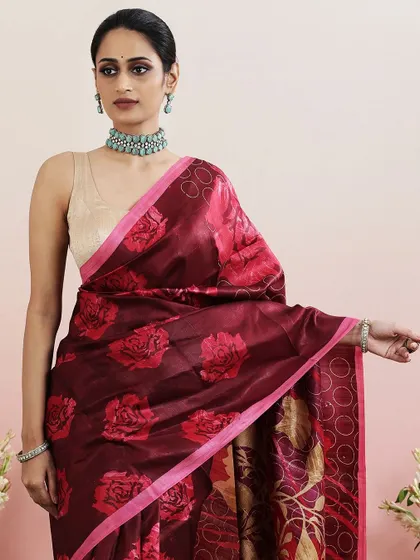 A close-up of the maroon floral printed saree, paired with a simple beige blouse and a statement choker.