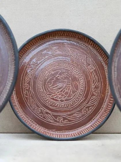 Inspired by antique bronze plates, these intricately carved ceramic plates were crafted by a student in our Foundation course. The detailed sgraffito work and rich glaze give them a timeless, heirloom quality.
