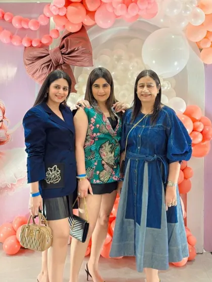Happy guests posing for a photo in front of the beautiful pink and peach balloon backdrop.