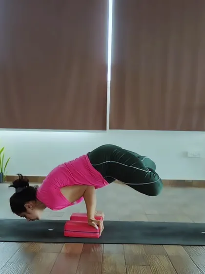 This is Padma Mayurasana, or Lotus in Peacock Pose. It's an advanced variation that combines the strength of Mayurasana with the hip flexibility of Padmasana (Lotus Pose).