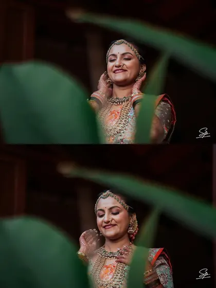 A creative shot through foliage, creating a natural frame for the bride's happy expression. This technique adds depth and an artistic touch to our portraits.