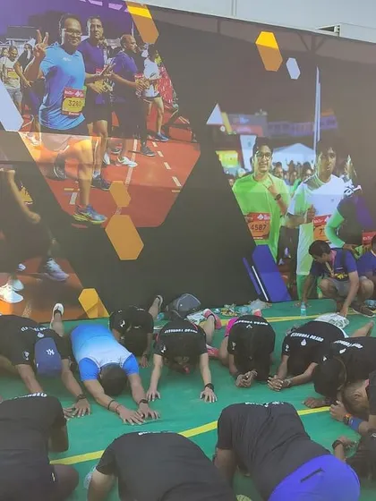 The team in a forward fold, a simple but effective hamstring stretch. We hold these poses to lengthen the muscles that get tight during a run, which is a key part of our injury prevention strategy.