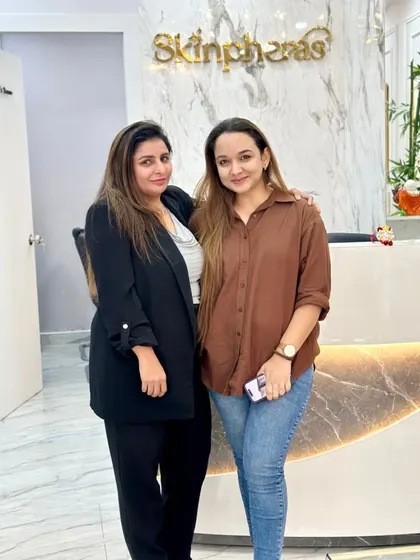 A happy client posing with our founder, Dr. Ritu, at the clinic's reception. We cherish the relationships we build with everyone who walks through our doors.