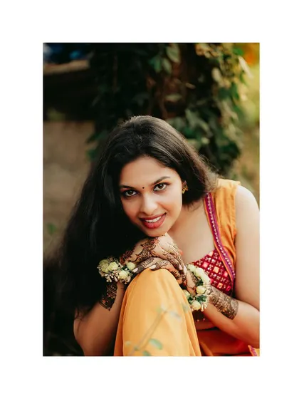 A beautiful close-up portrait of the bride, focusing on her smile and intricate mehendi.