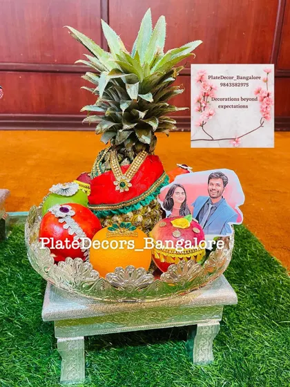 Another example of a personalized wedding fruit platter with a pineapple bride and a photo of the couple, surrounded by decorated fruits.