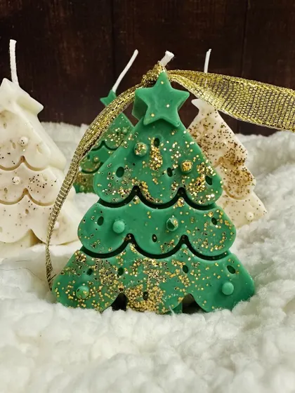A green Christmas tree soy candle sparkling with gold glitter, a perfect addition to your holiday decor.