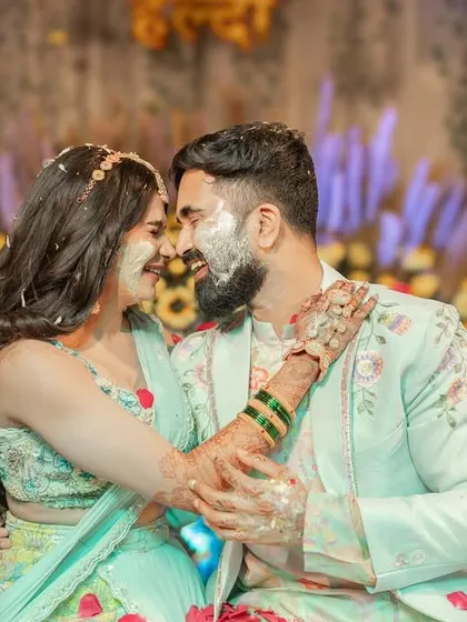 A romantic shot of a couple during their Haldi ceremony. The bride's floral dupatta, made by us, beautifully complements the festive and joyful atmosphere.