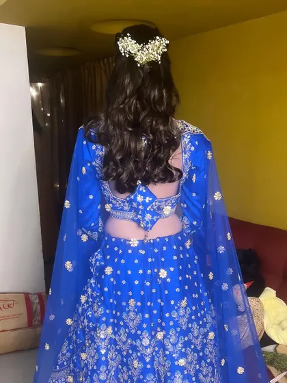 Another view of the back, showing the detailed work on the lehenga and the elegant hairstyle.