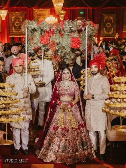 The bride's grand entry, with her path lit by attendants holding tiered candle stands.