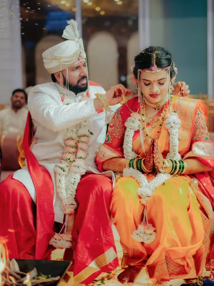 A sacred moment during the wedding ceremony as the groom ties the mangalsutra around the bride's neck.