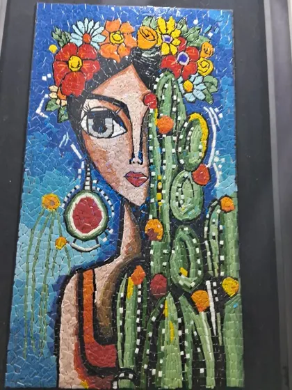 A colorful mosaic portrait of a woman with flowers in her hair, inspired by Frida Kahlo, by artist Nagla.
