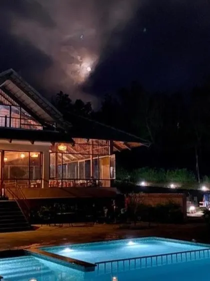 A night view of the pool and main building at a Sakleshpur resort, perfect for a late-night swim under the stars.