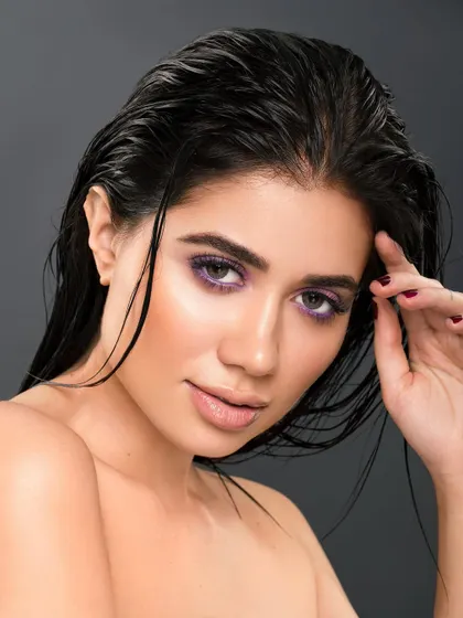 Another angle from the same series, this shot captures a more dynamic and expressive pose. The lighting highlights the sheen on the hair and the vibrant color of the eyeshadow.