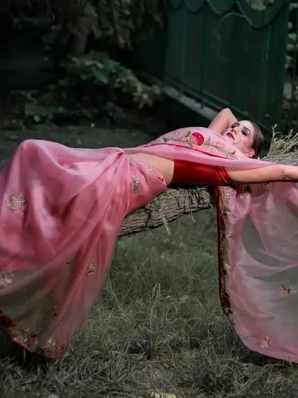 A slightly different angle of the dramatic reclining pose, focusing on the model's expression and the flow of the saree's pallu.