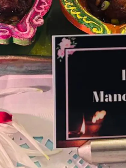 A close-up of the food label for "Dry Manchurian" next to the creative diya presentation. I ensure all my dishes are clearly labeled so guests know what they are enjoying.