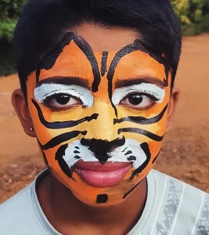 Face painting is a fun and creative activity at our camps. Here, a participant is transformed into a tiger.