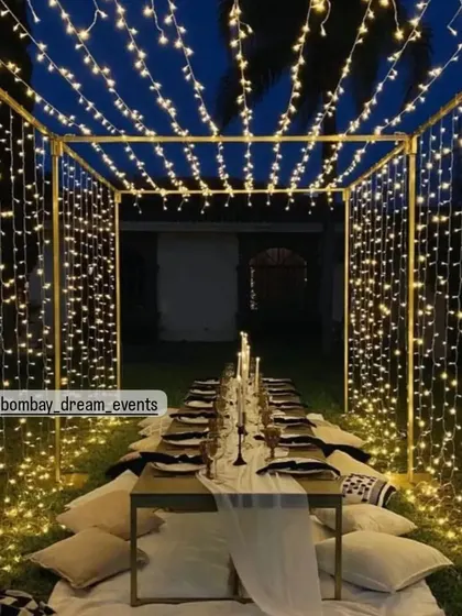 I transform outdoor spaces into magical dining experiences. This fairy light canopy creates a starlit effect for an intimate dinner party, perfect for birthdays or anniversaries under the open sky.