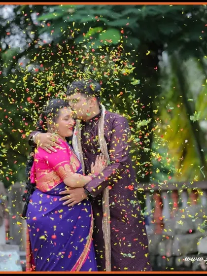 A romantic outdoor portrait of the couple showered in confetti. The vibrant colors of their outfits and the festive atmosphere make this a truly celebratory shot.