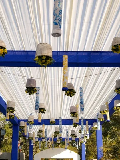 A close-up of the hanging decor elements, featuring custom-printed fabric and small floral baskets that match the blue and white theme.