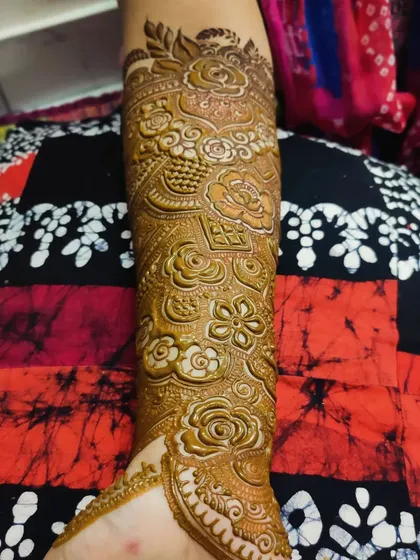 A close-up of an arm band from a bridal design, showing the 3D effect of the fresh henna paste.