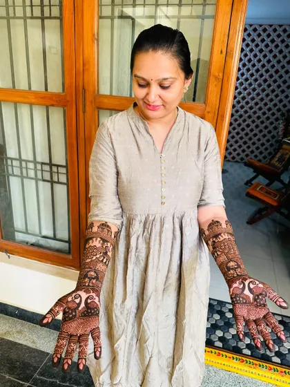 A simple and sweet shot of a bride admiring her full-arm traditional henna.