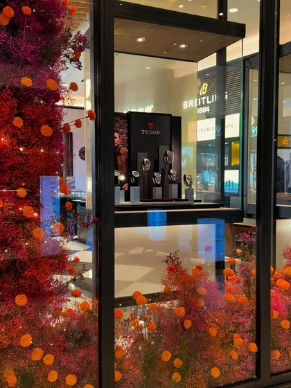 Store windows are a fantastic canvas for joyful floral installations. For this luxury storefront, I used a fiery palette of red and orange dried florals to create a vibrant and eye-catching display that draws you in.