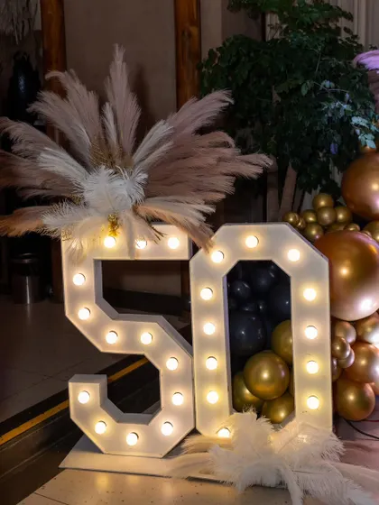 Large light-up marquee numbers are a fantastic way to highlight a milestone birthday. For this 50th, I added pampas grass and feather details for an extra touch of glamour.